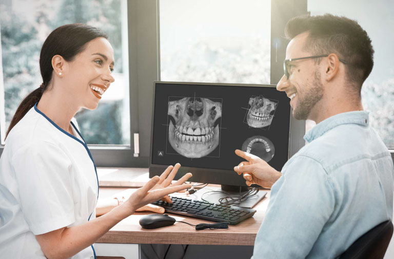 Photo ID: H06. Computer diagnostics dental tomography. Dentist shows the patient an x-ray image at display.