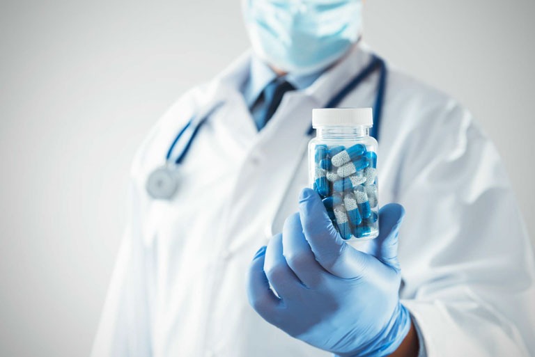 Photo ID: H13. Doctor holding blue pills in bottle. Healthcare, medical research concept