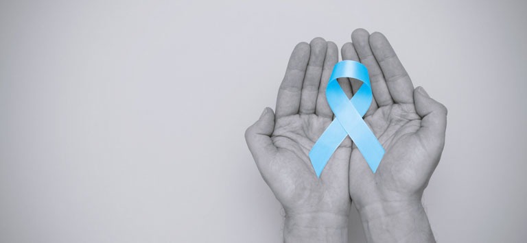 Photo ID: H15. Hand holding blue prostate cancer awareness ribbon with copy space