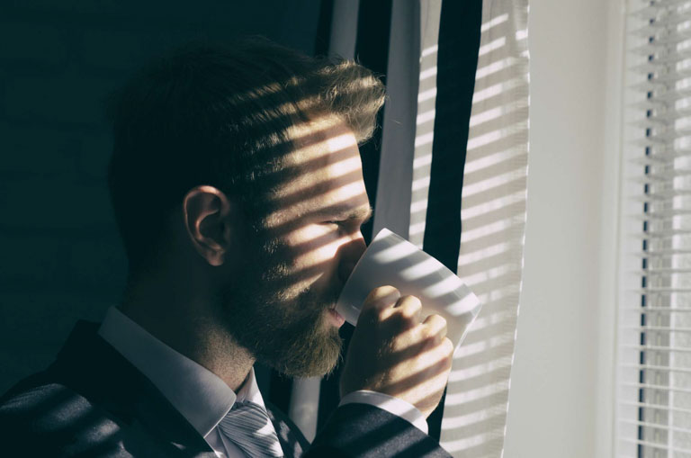 Photo ID: L01. Handsome young bearded businessman is looking out the window and drinking coffee