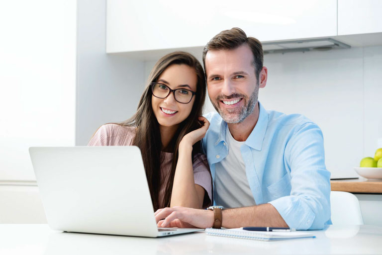 Photo ID: L18. Smiling couple sitting at the computer. Financial concept, beautiful white smile