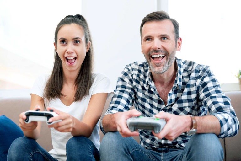 Photo ID: L21. Couple playing computer games, playing the console, holding pads in their hands