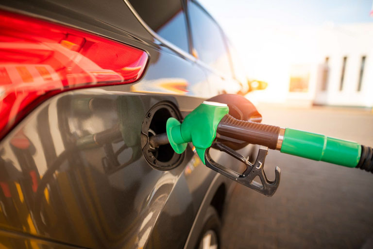 Photo ID: T02. Closeup of man pumping gasoline fuel in car at gas station.